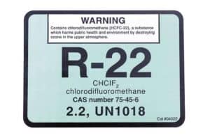Label for R-22 chlorodifluoromethane with warning about ozone harm, chemical details, CAS number 75-45-6, and UN1018 identifier.