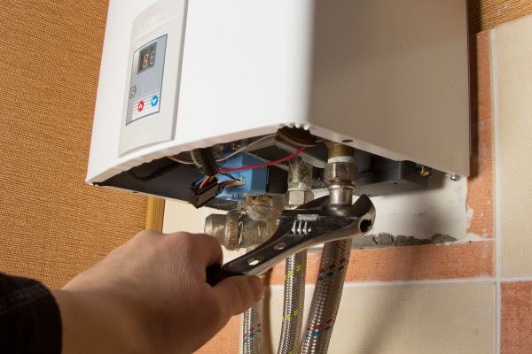 Plumber Working On A Tankless Hot Water Heater